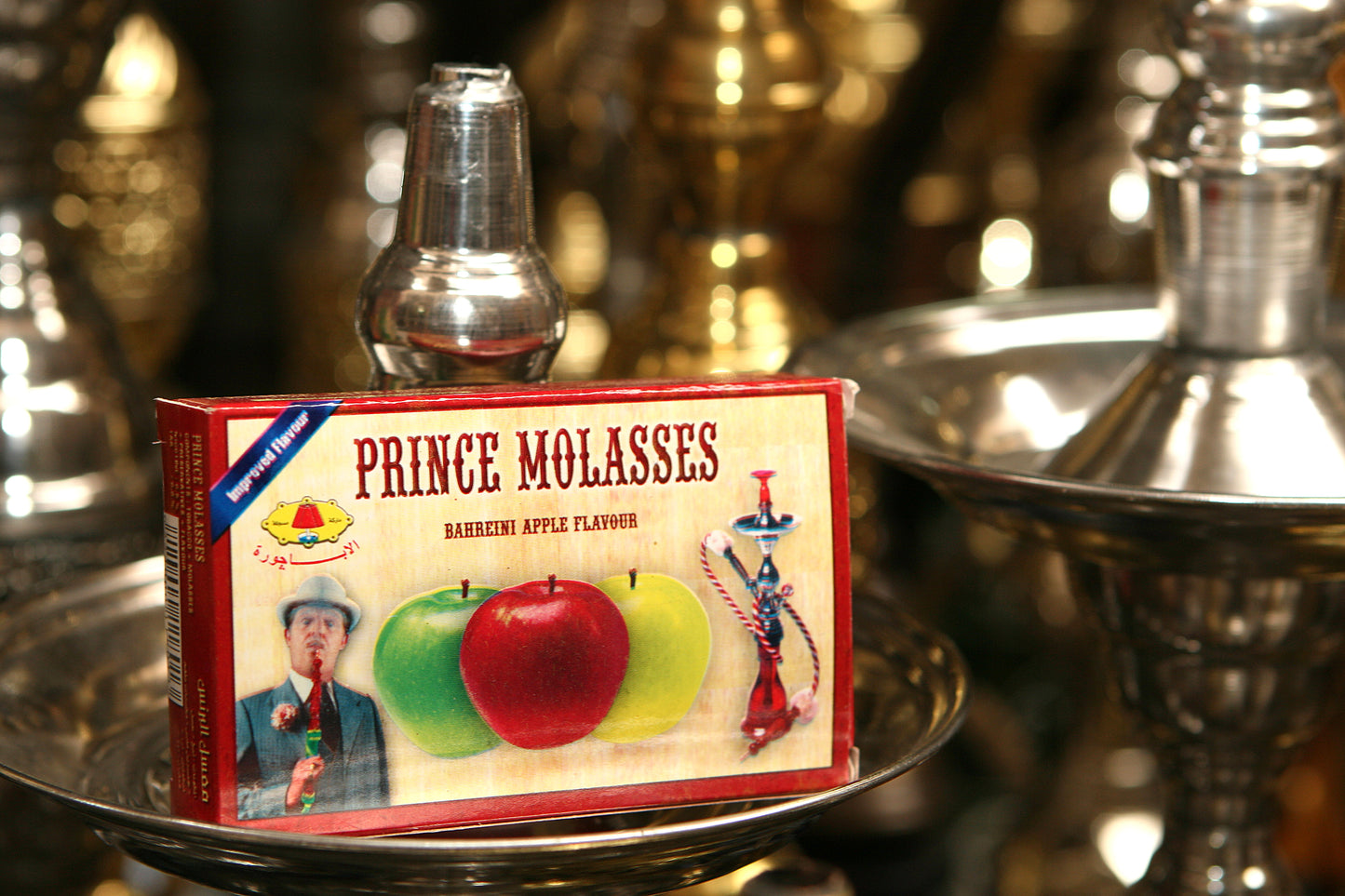 Box of Prince Molasses apple flavour shisha tobacco displayed among hookahs