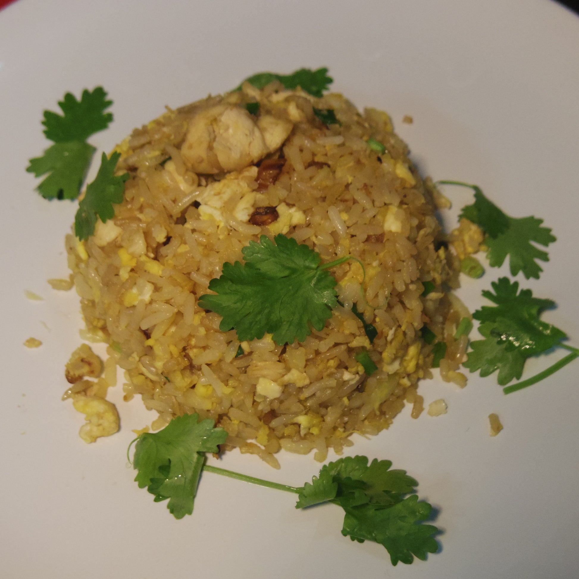 Plate of chicken fried rice garnished with coriander