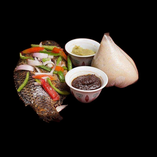 Banku and grilled tilapia on black background