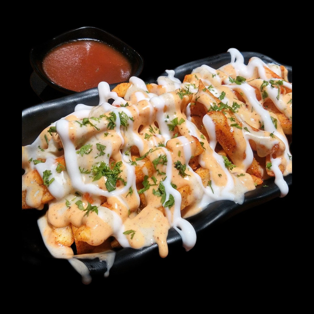 Loaded fries with crispy chicken on black background