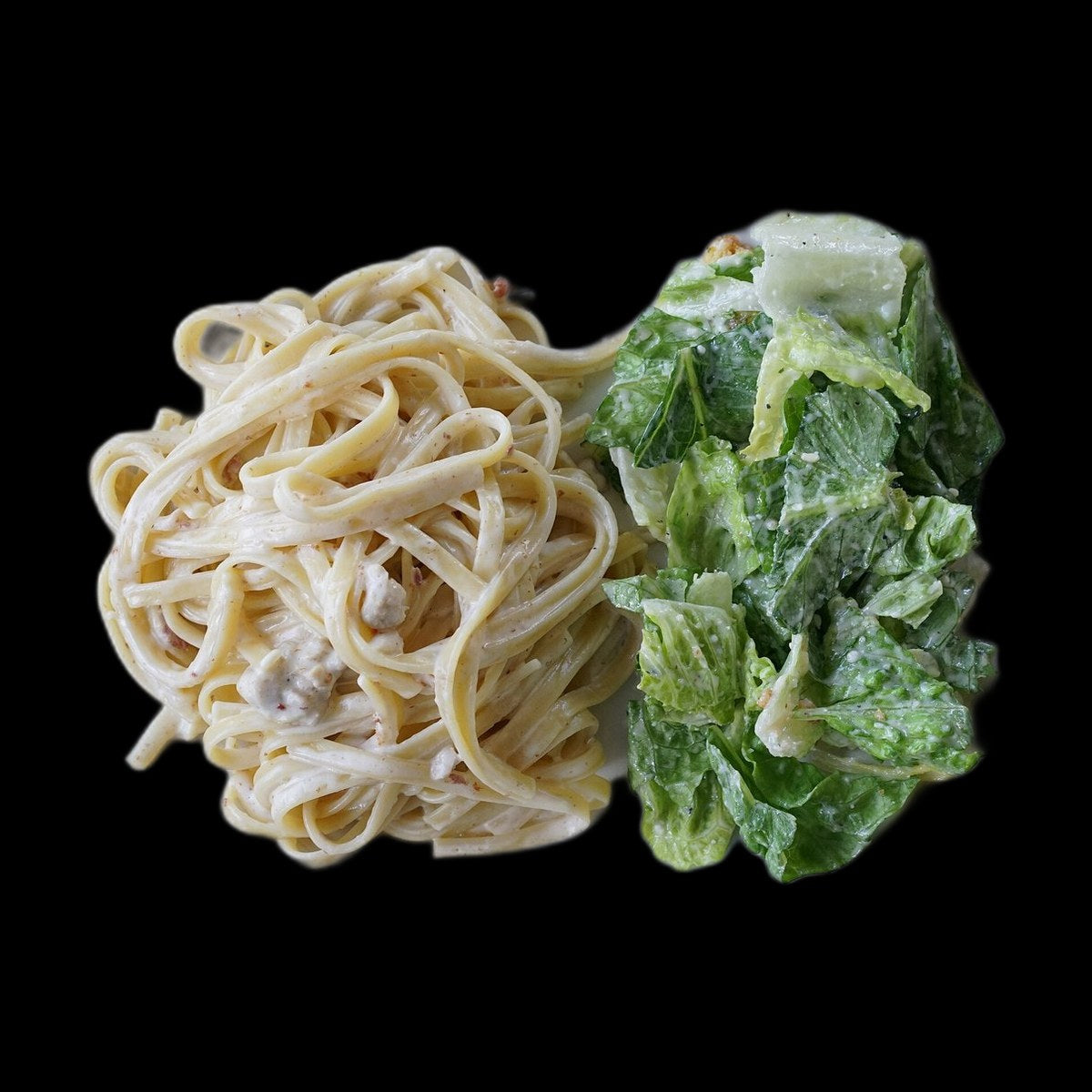 Chicken alfredo pasta on black background